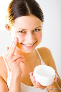 Woman applying face lotion