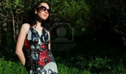 7712494-the-girl-in-a-beautiful-dress-and-sun-glasses-walks-in-a-garden