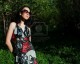 7712494-the-girl-in-a-beautiful-dress-and-sun-glasses-walks-in-a-garden