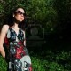 7712494-the-girl-in-a-beautiful-dress-and-sun-glasses-walks-in-a-garden