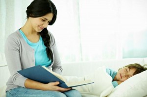 Young mother reading to her sleeping daughter