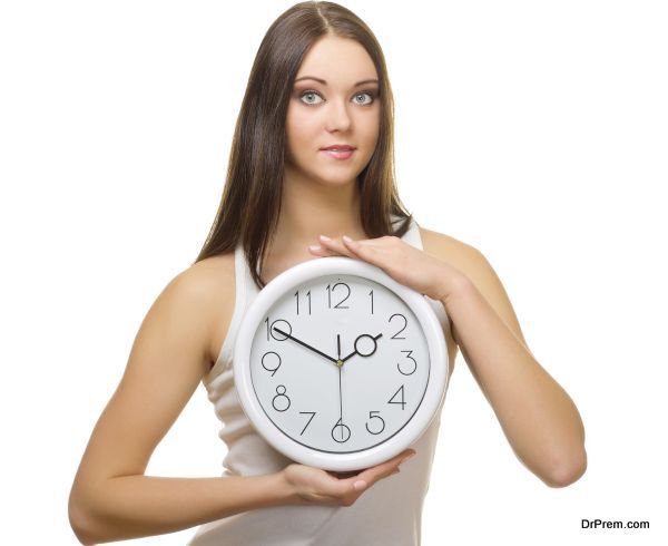 Young girl with clock isolated