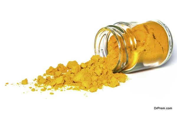 Spilled dose of turmeric spice powder isolated on white background