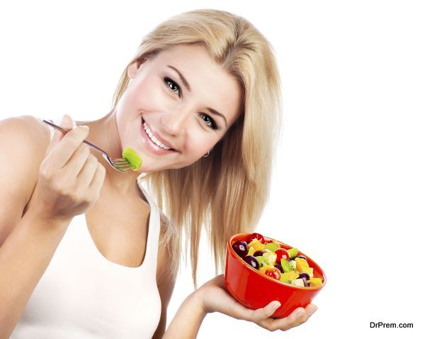 Pretty girl eating fruit salad