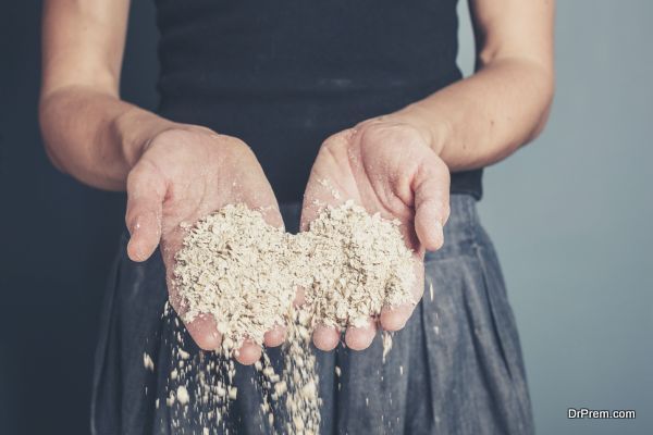 A young woman is standing with a handful of oats