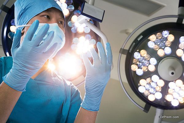 Low angle view of surgeon holding gloved hands up