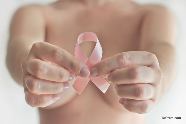 woman hand holding pink ribbon, a breast cancer symbol