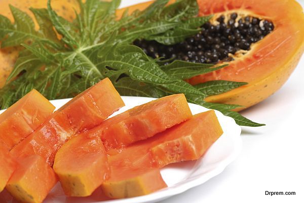 Ripe papaya, slices with seeds and green leaf